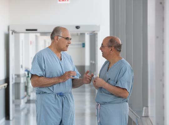 Dr. Bernard Bach and Dr. Charles Bush-Joseph talking in hospital hallway