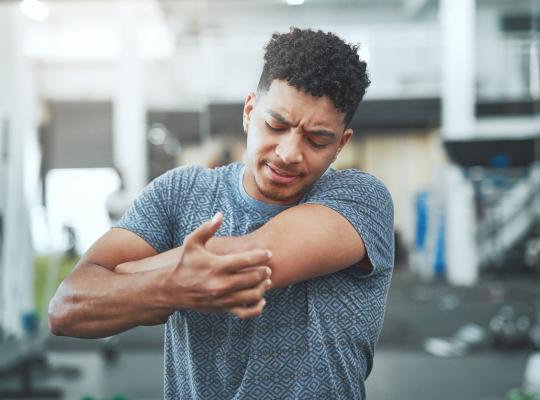Man touching elbow in pain