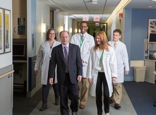 Dr. Goldberg walking in hallway with clinical staff